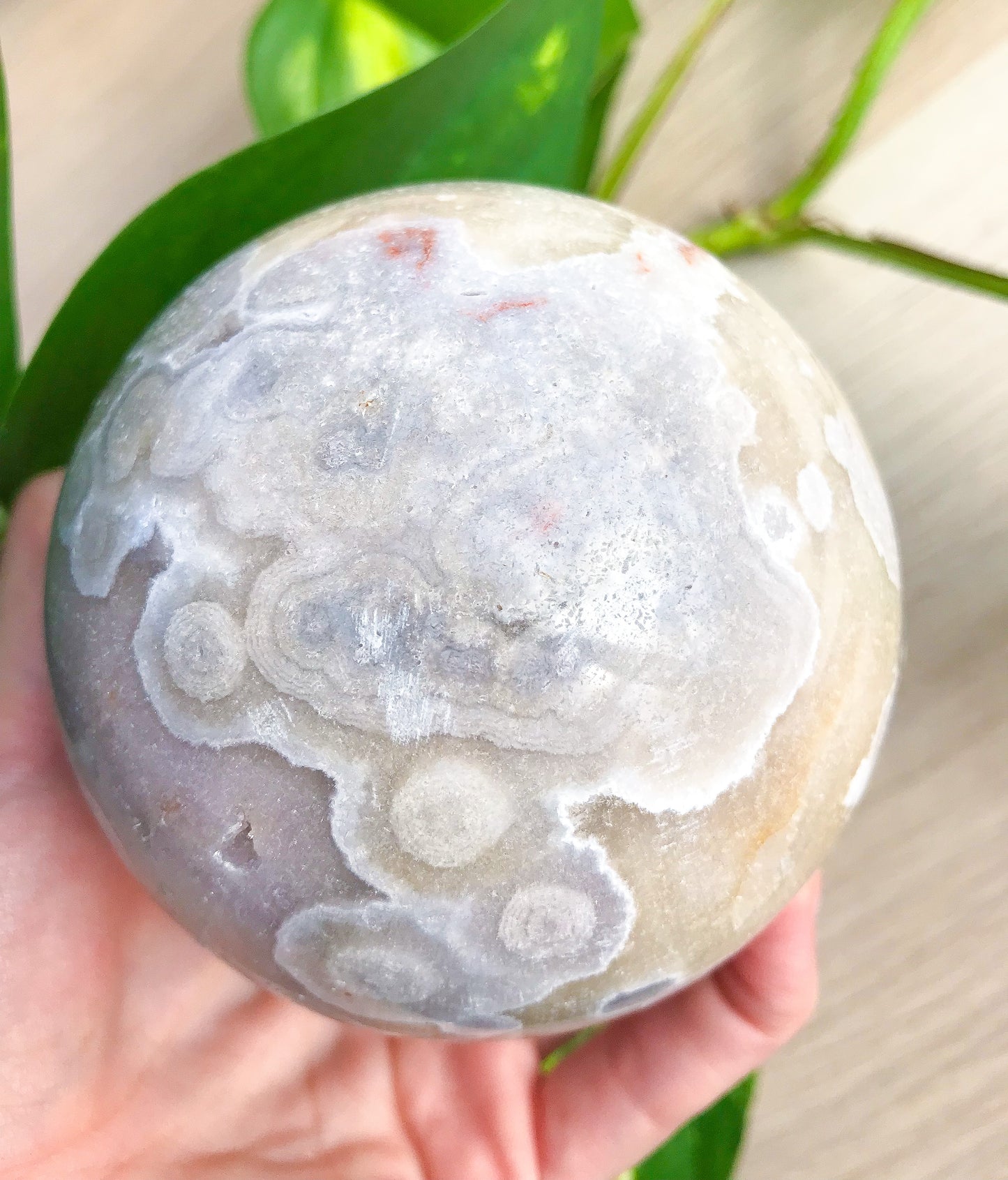 闪闪发光的圆形花粉红色紫水晶球体带玛瑙内含物