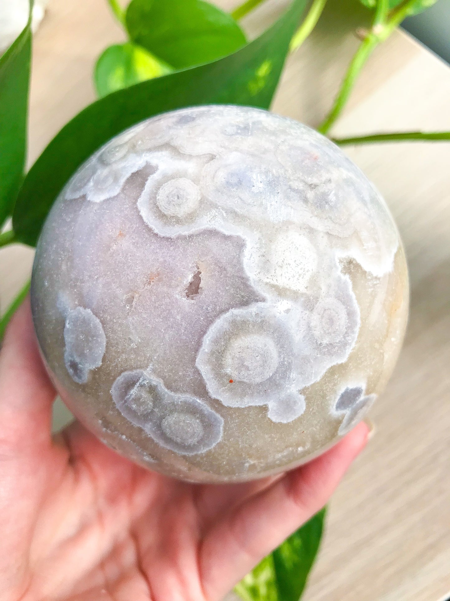 闪闪发光的圆形花粉红色紫水晶球体带玛瑙内含物