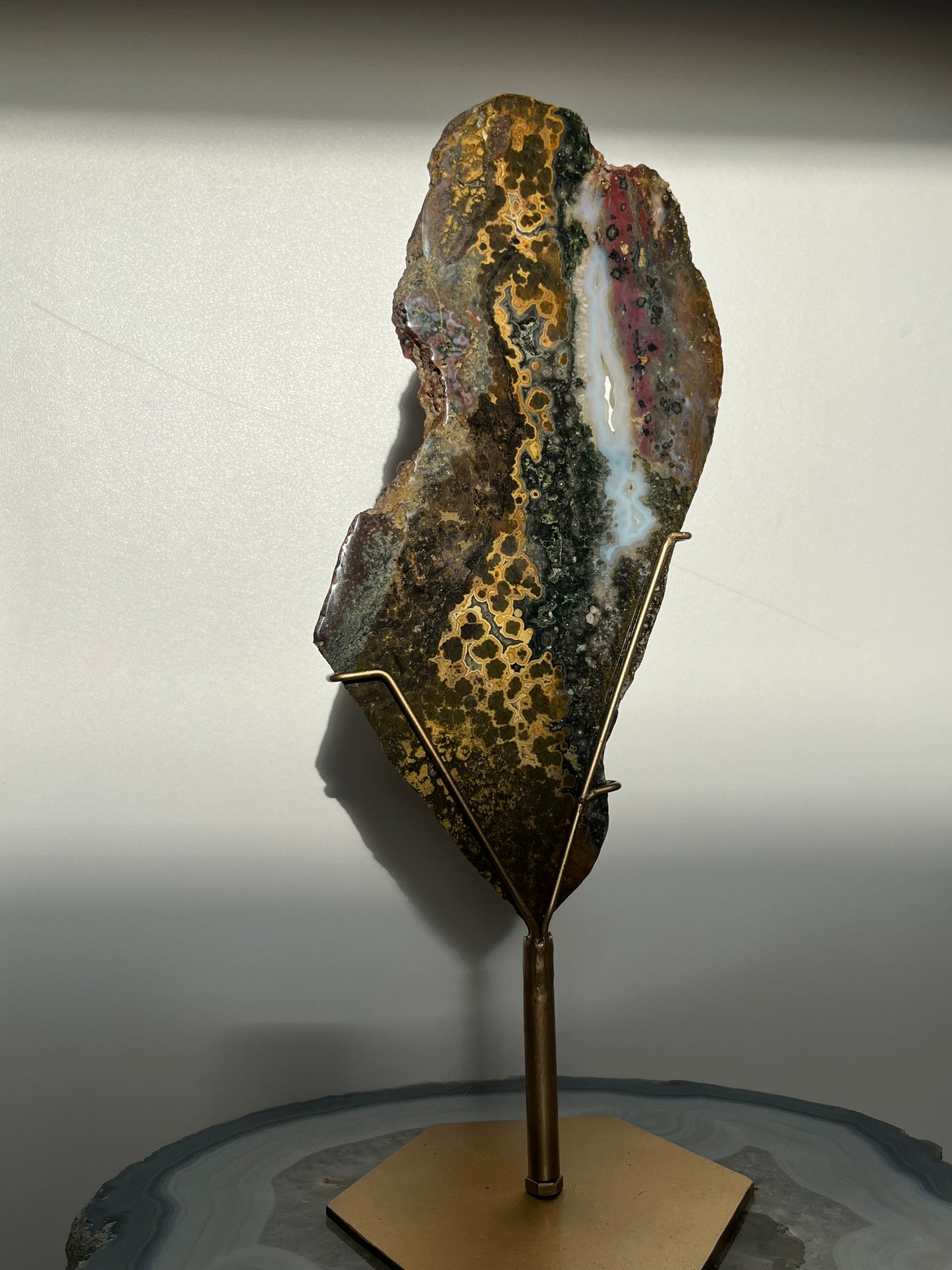 Multicoloured River Jasper Slab with Dendritic Inclusions on Rotating Gold Coloured Stand